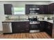 Updated kitchen featuring stainless steel appliances, granite countertops, and dark wood cabinets at 4950 Nova Ave, St Cloud, FL 34773
