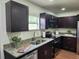 Close up of kitchen with granite countertops, stainless steel appliances and dark wood cabinets at 4950 Nova Ave, St Cloud, FL 34773