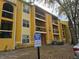 View of a yellow two-story apartment complex building with balconies and a handicapped parking sign at 5267 Images Cir # 303, Kissimmee, FL 34746