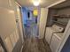 Hallway with a laundry closet, washer and dryer, and wood-look flooring at 5267 Images Cir # 303, Kissimmee, FL 34746