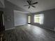 Living room featuring wood-look flooring, neutral gray walls, ceiling fan and a window at 5267 Images Cir # 303, Kissimmee, FL 34746