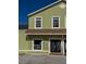 A two-story green home with a brown shingle roof and a bright blue sky above at 1069 Universal Rest Pl, Kissimmee, FL 34744