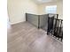 Upstairs hallway with modern flooring, black metal railing, and view of bright interior at 1069 Universal Rest Pl, Kissimmee, FL 34744