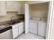 Kitchen featuring white cabinets, granite countertops, and a laundry area at 1069 Universal Rest Pl, Kissimmee, FL 34744