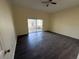 Spacious living room with sliding glass doors and wood-look laminate flooring at 1069 Universal Rest Pl, Kissimmee, FL 34744