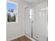 Bathroom with tiled shower, single window and wood-look tile floor at 1740 Carnelian St, Deland, FL 32720