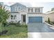 Two-story home with gray and blue exterior, two-car garage, and landscaping at 1740 Carnelian St, Deland, FL 32720