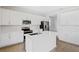 Modern kitchen with white cabinets, island, and stainless steel appliances at 1740 Carnelian St, Deland, FL 32720