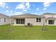Backyard featuring a green lawn, young trees, and a covered patio at 1742 Carnelian St, Deland, FL 32720