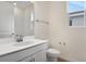 Clean bathroom with a white vanity, toilet, and a window for natural light at 1742 Carnelian St, Deland, FL 32720