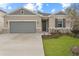 Charming single-story home featuring a gray front door and a concrete driveway at 1742 Carnelian St, Deland, FL 32720