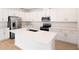 Modern kitchen featuring white cabinetry, stainless steel appliances, and a large island at 1742 Carnelian St, Deland, FL 32720