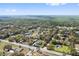 Scenic aerial shot of a residential area with diverse homes and a backdrop of a vibrant green forest under a clear blue sky at 1810 Markham Woods Rd, Longwood, FL 32779
