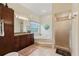 Bathroom featuring a soaking tub, walk-in shower, wood cabinets, and a round window at 1810 Markham Woods Rd, Longwood, FL 32779