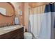 Bathroom with granite sink, round mirror, neutral paint, toilet, and patterned shower curtain at 1810 Markham Woods Rd, Longwood, FL 32779