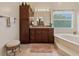 A traditional bathroom with a granite countertop, soaking tub, and ample cabinet space at 1810 Markham Woods Rd, Longwood, FL 32779