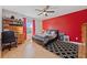 This bright bedroom has a ceiling fan, closet and desk near the bright red accent wall at 1810 Markham Woods Rd, Longwood, FL 32779
