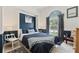 Charming bedroom features a large window, blue accent wall, and stylish furnishings at 1810 Markham Woods Rd, Longwood, FL 32779