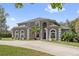 Stunning two-story home featuring arched windows, manicured landscaping and a long driveway at 1810 Markham Woods Rd, Longwood, FL 32779