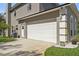 Spacious two-car garage with white doors and adjacent side entrance at 1810 Markham Woods Rd, Longwood, FL 32779