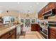 Kitchen with stainless appliances, granite counters, cherry cabinets, and adjacent breakfast nook at 1810 Markham Woods Rd, Longwood, FL 32779