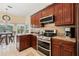 Kitchen with stainless steel appliances, granite counters, and cherry wood cabinets at 1810 Markham Woods Rd, Longwood, FL 32779