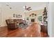 Cozy living room boasts a fireplace, hardwood floors, ceiling fan, and a comfortable leather sofa at 1810 Markham Woods Rd, Longwood, FL 32779