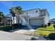 Two-story house with gray and white exterior, three-car garage, and palm trees at 3850 Oakville Ave, Kissimmee, FL 34741
