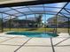 Screened-in rectangular pool with a view of the surrounding homes at 3850 Oakville Ave, Kissimmee, FL 34741