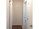 Bright hallway with white walls and doors, plus attractive wood-look flooring leading to carpeted rooms at 4815 Jay Dr, St Cloud, FL 34772