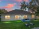 Backyard view at sunset with patio furniture at 545 Pintail Cir, Auburndale, FL 33823