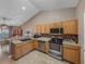 Modern kitchen with wood cabinets, stainless steel appliances, and tile flooring at 545 Pintail Cir, Auburndale, FL 33823