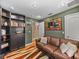 Cozy library features built-in bookshelves and a comfortable leather couch at 545 Pintail Cir, Auburndale, FL 33823