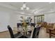 Dining area with glass-top table and four black chairs, near living room at 8121 Roseville Blvd, Davenport, FL 33896