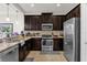 Modern kitchen featuring dark wood cabinets, granite countertops, and stainless steel appliances at 8121 Roseville Blvd, Davenport, FL 33896