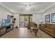 Living room with brown couch and access to a patio or backyard at 8121 Roseville Blvd, Davenport, FL 33896