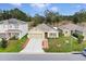 Aerial view of a tan house on a tree-lined street at 965 Shady Tree Ln, Davenport, FL 33897