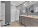 Bathroom with double vanity, large mirror, and a shower with glass enclosure at 965 Shady Tree Ln, Davenport, FL 33897
