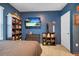 Bedroom with mounted TV, dresser, and shelving at 965 Shady Tree Ln, Davenport, FL 33897