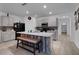 Open kitchen features gray cabinets, an island with bench seating, and hardwood floors at 965 Shady Tree Ln, Davenport, FL 33897