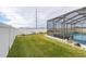 Large backyard with a screened pool and white vinyl fence at 113 Promenade Ct, Auburndale, FL 33823