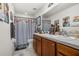 Clean bathroom with wood vanity, shower, and decorative shower curtain at 113 Promenade Ct, Auburndale, FL 33823