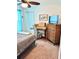 Bedroom boasts a desk, natural-tone dresser, and comfortable bed with blue curtains and ceiling fan at 113 Promenade Ct, Auburndale, FL 33823