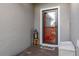 Front entry with red door, welcome mat, and lantern decor at 113 Promenade Ct, Auburndale, FL 33823