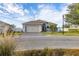 Single-story home with gray exterior, paver driveway, and landscaped lawn at 113 Promenade Ct, Auburndale, FL 33823