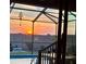 Gorgeous pool and sunset view from screened lanai with stylish outdoor space and fire pit at 113 Promenade Ct, Auburndale, FL 33823