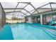 Enjoy this refreshing screened pool with outdoor kitchen and seating at 113 Promenade Ct, Auburndale, FL 33823
