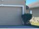 Two car garage with tan exterior and a house number at 137 Milestone Dr, Haines City, FL 33844