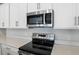 Modern kitchen featuring stainless steel appliances and white quartz countertops at 211 Bull Frog Ln, Umatilla, FL 32784