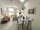 Bright dining area with a glass table and four chairs, adjacent to the living room at 2511 La Jolla Trl, Kissimmee, FL 34747